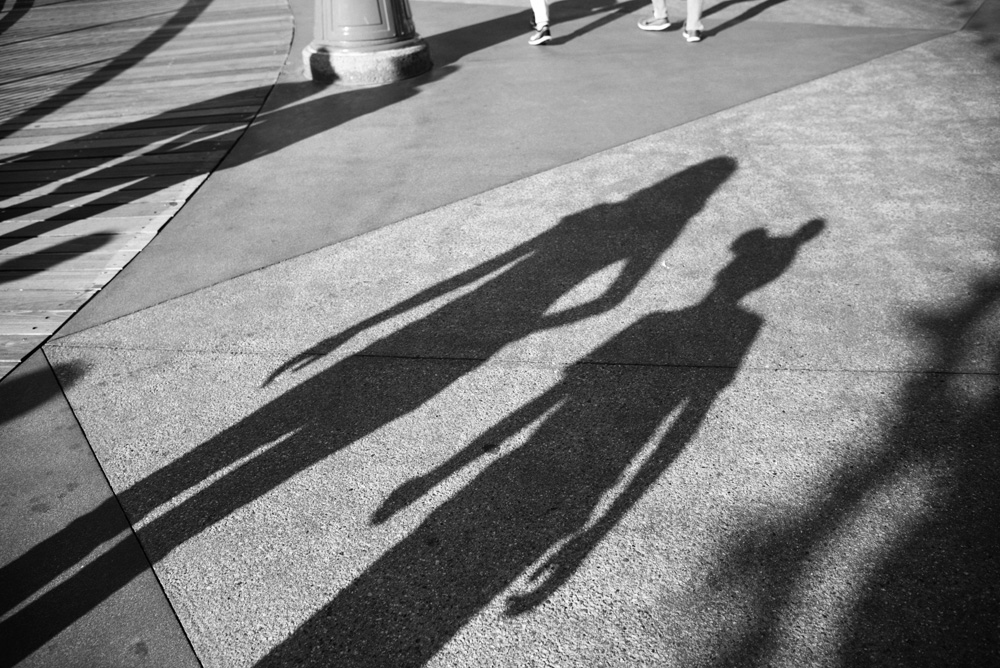 shadow of two people with one person wearing a mickey mouse hat