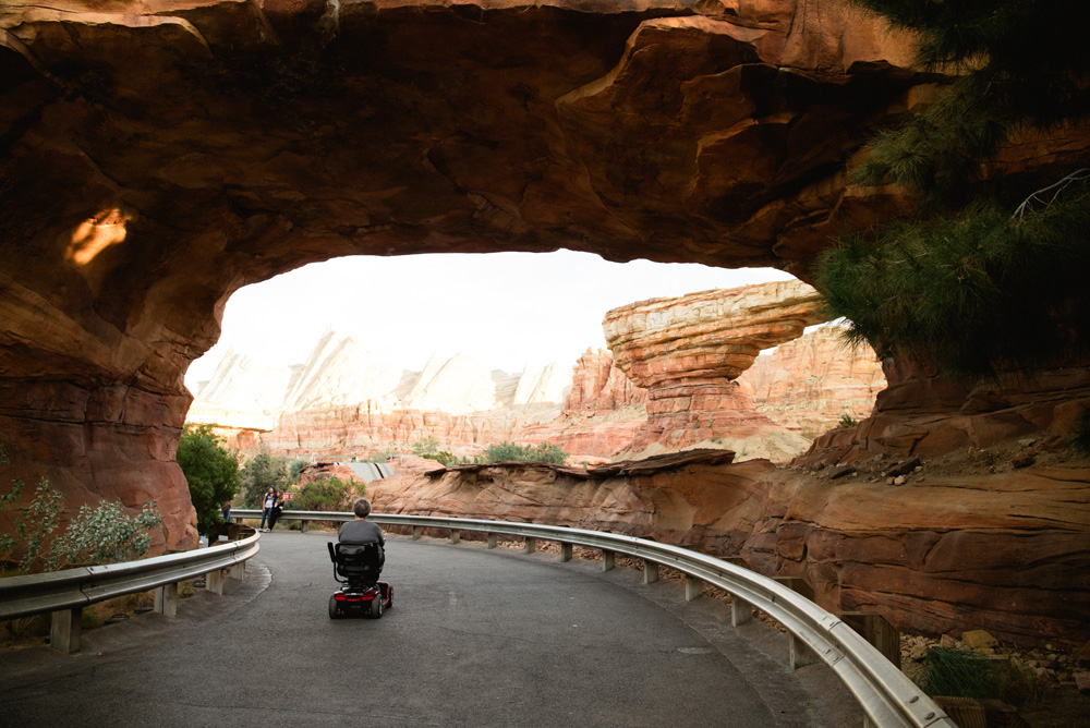 a woman riding a scooter through a canyon